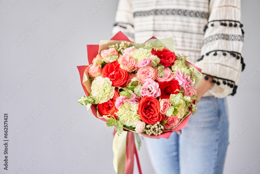 Small Beautiful bouquets of mixed flowers in woman hand. Floral shop concept . Beautiful fresh cut bouquet. Flowers delivery