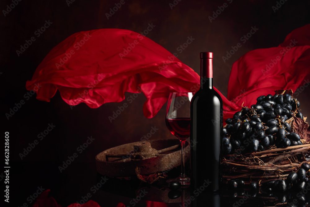 Red wine with grapes on a background of red flutters curtain.