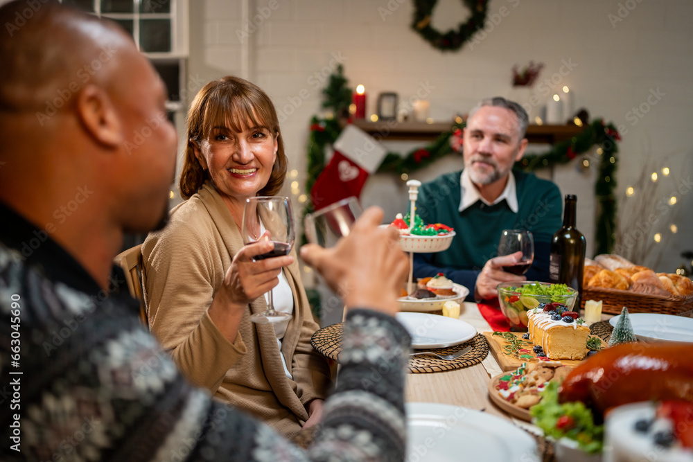 Multi-ethnic big family celebrating Christmas party together in house. 