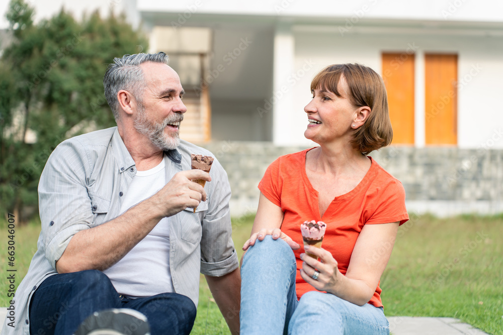 Caucasian senior man and woman having a picnic outdoors in the garden. 