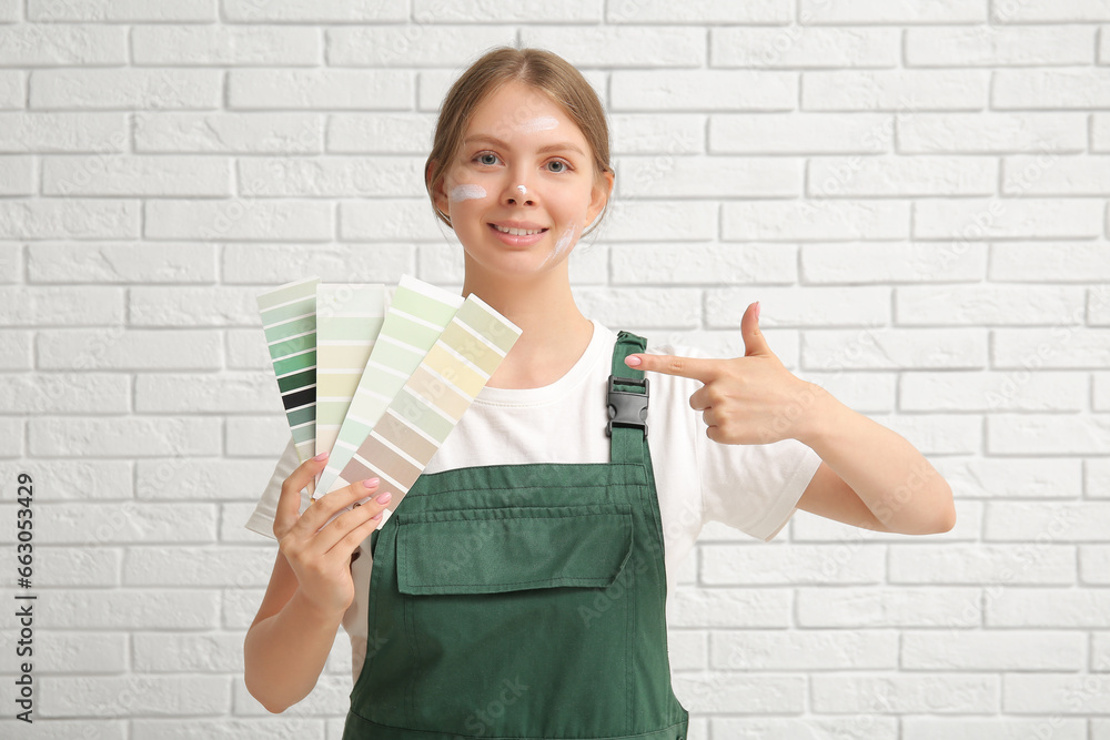 Female decorator with color samples on white brick background