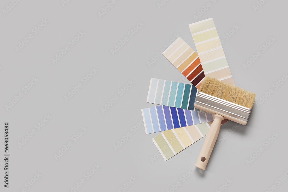 Many color palettes and brush on grey background, top view