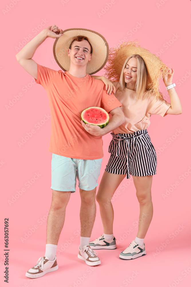 Young beautiful man and woman with half of fresh watermelon on pink background