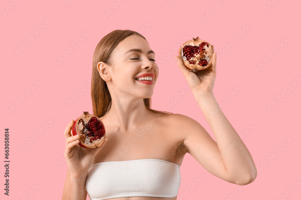 Young woman with pomegranate on pink background