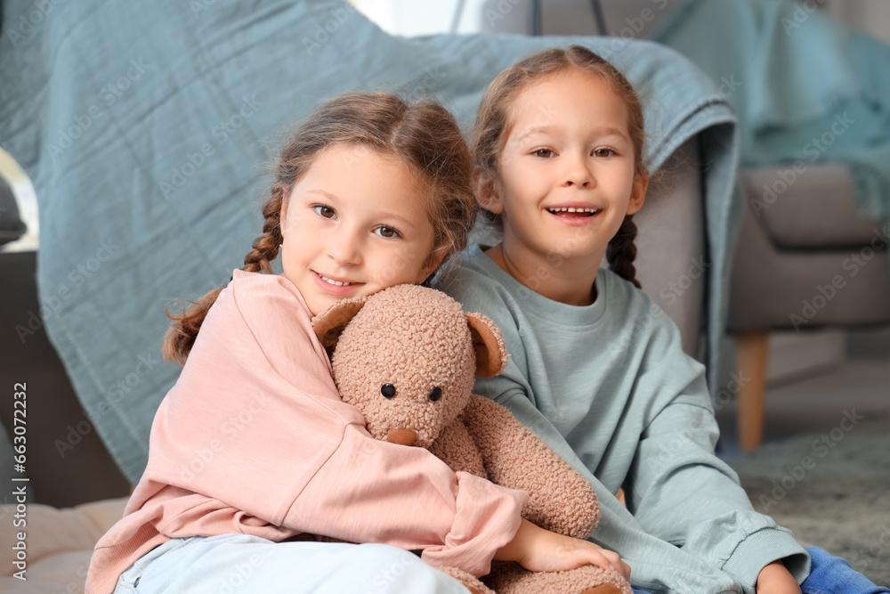 Cute little girls with toy bear at home