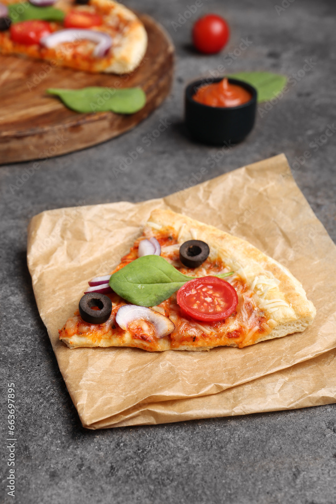 Baking paper with slice and board of tasty pizza on dark background