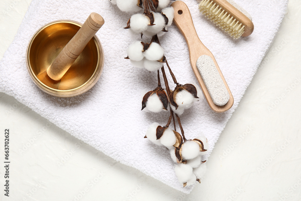 Composition with massage brushes, clean towel, mortar and cotton branch on light background