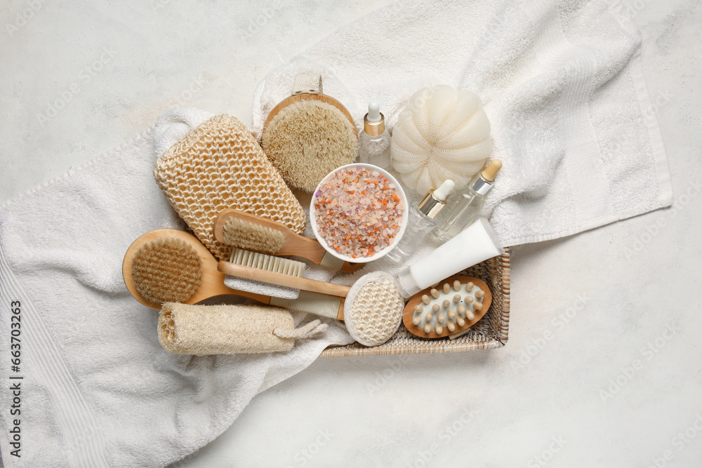 Basket with bath supplies and cosmetic products on light background