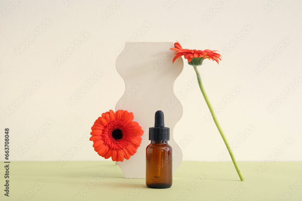 Composition with bottle of essential oil, plaster podium and beautiful gerbera flowers on color background