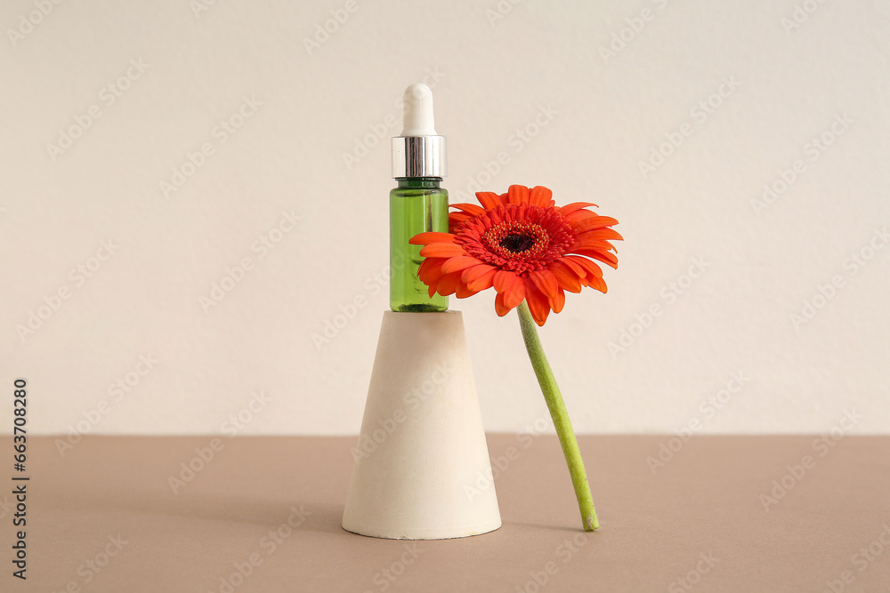 Composition with bottle of essential oil, plaster podium and beautiful gerbera flower on color background