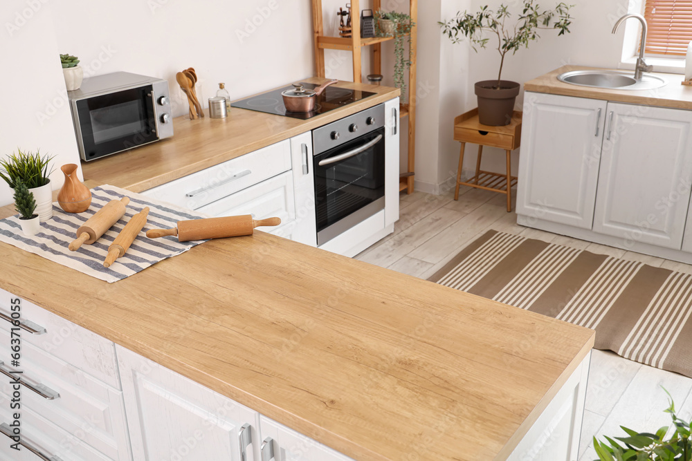 Interior of light kitchen with white counters and striped carpet