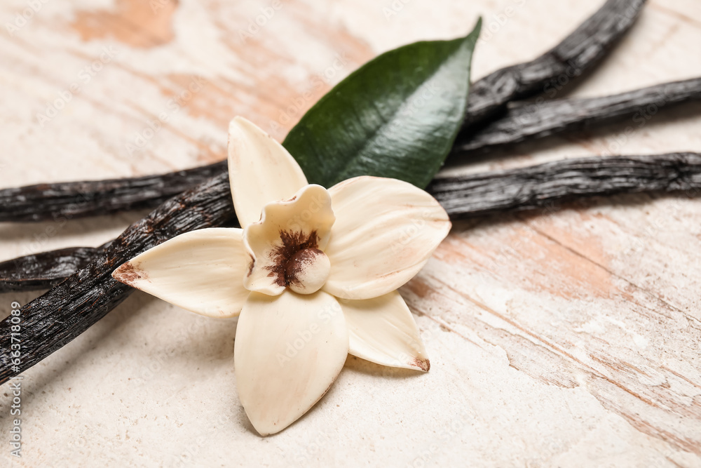 Aromatic vanilla sticks and flower on white wooden background