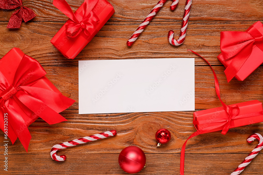 Beautiful Christmas composition with blank card, gift boxes and decor on wooden background