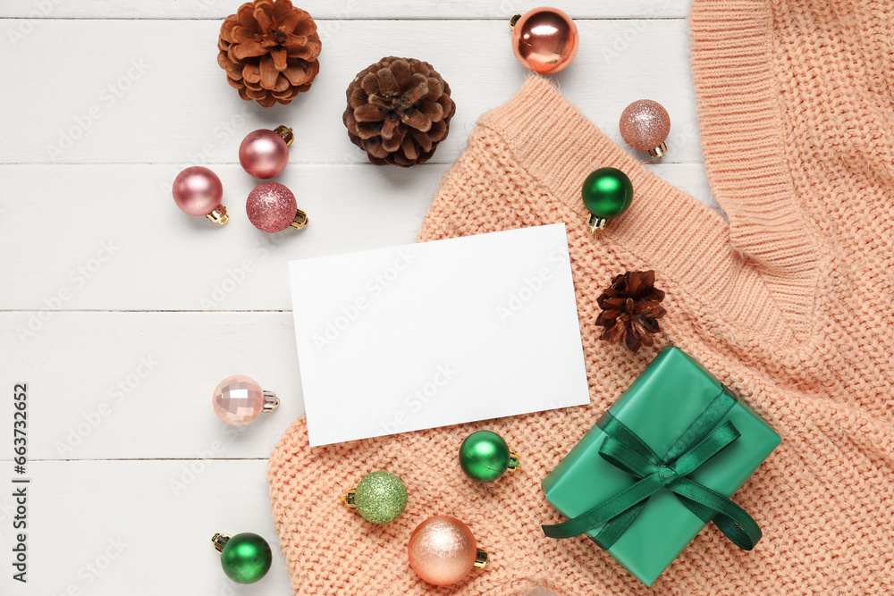 Beautiful Christmas composition with blank card, gift box and decor on white wooden background