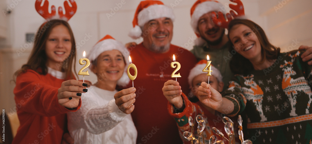 Christmas and New Year 2024 holiday concept, celebration of family, people. Smiling friends happily eating Christmas dinner at home in the evening.