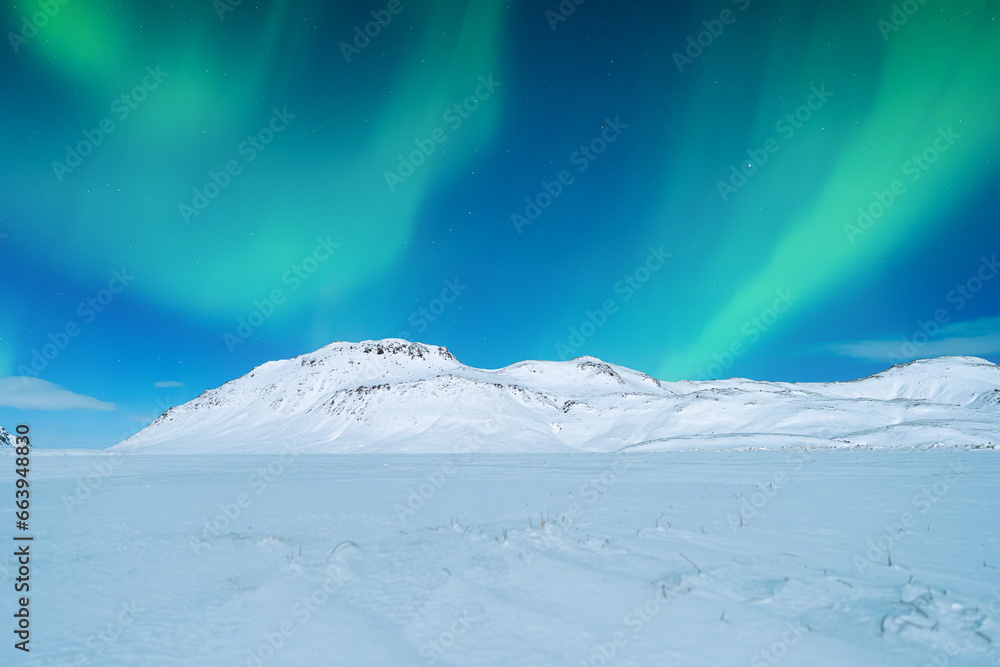 Aurora Borealis. Northern lights and clear skies. Nature. Scandinavian countries. Snow and ice on the mountains. Landscape in winter time. Photo for background and wallpaper.