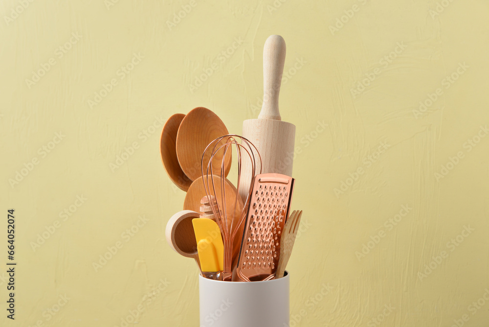 Set of baking utensils near yellow wall