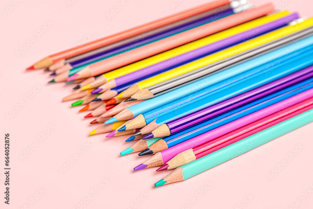 Heap of color pencils on pink background, closeup