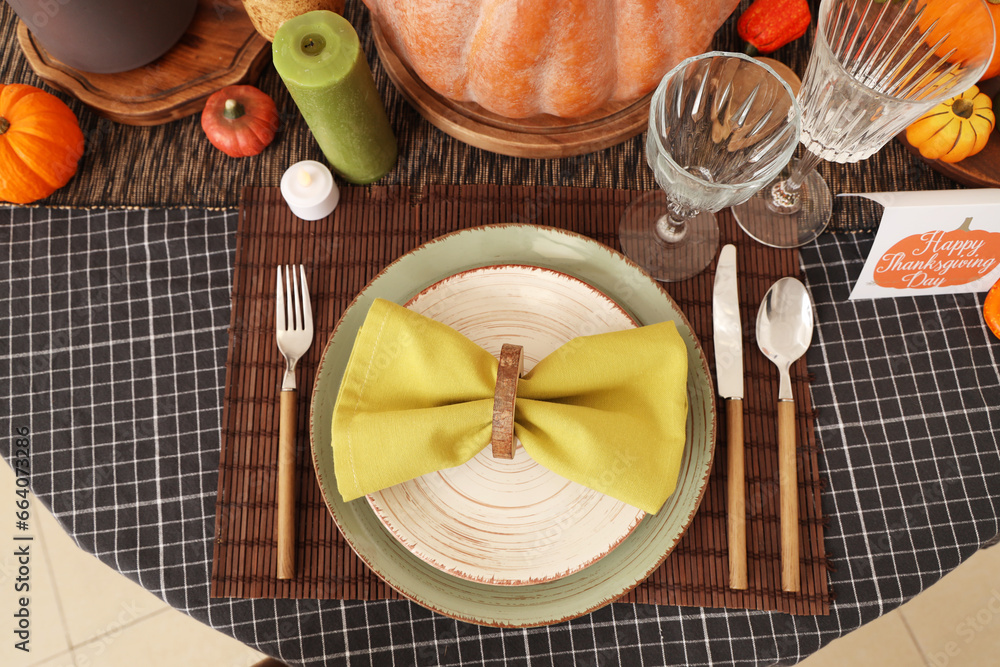 Thanksgiving table setting with pumpkins, cutlery and napkin, closeup