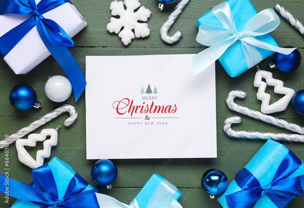 Beautiful Christmas composition with greeting card, gift boxes and decor on green wooden background