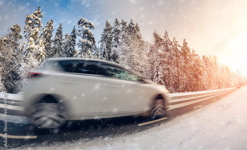 Car on the snowy road in natural park.