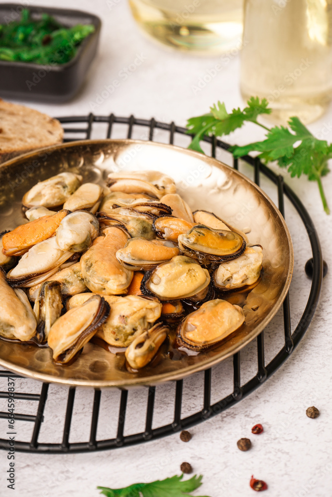 Plate of pickled mussels on grey background