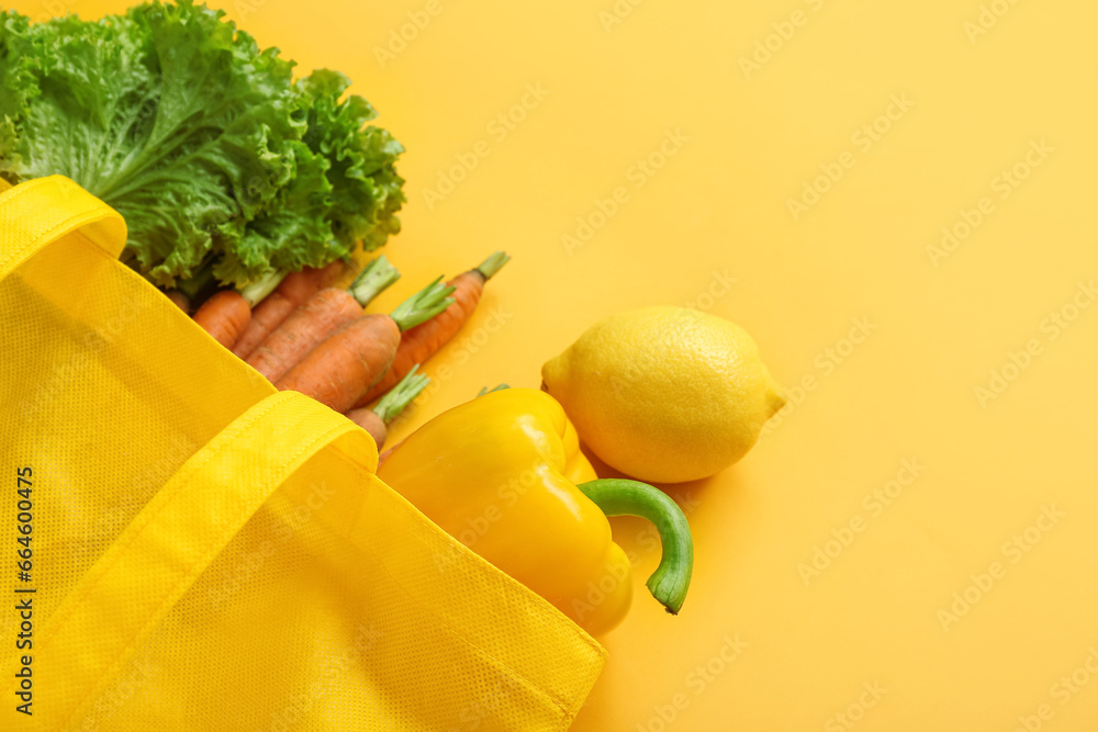 Eco bag with different fresh vegetables on beige background, closeup