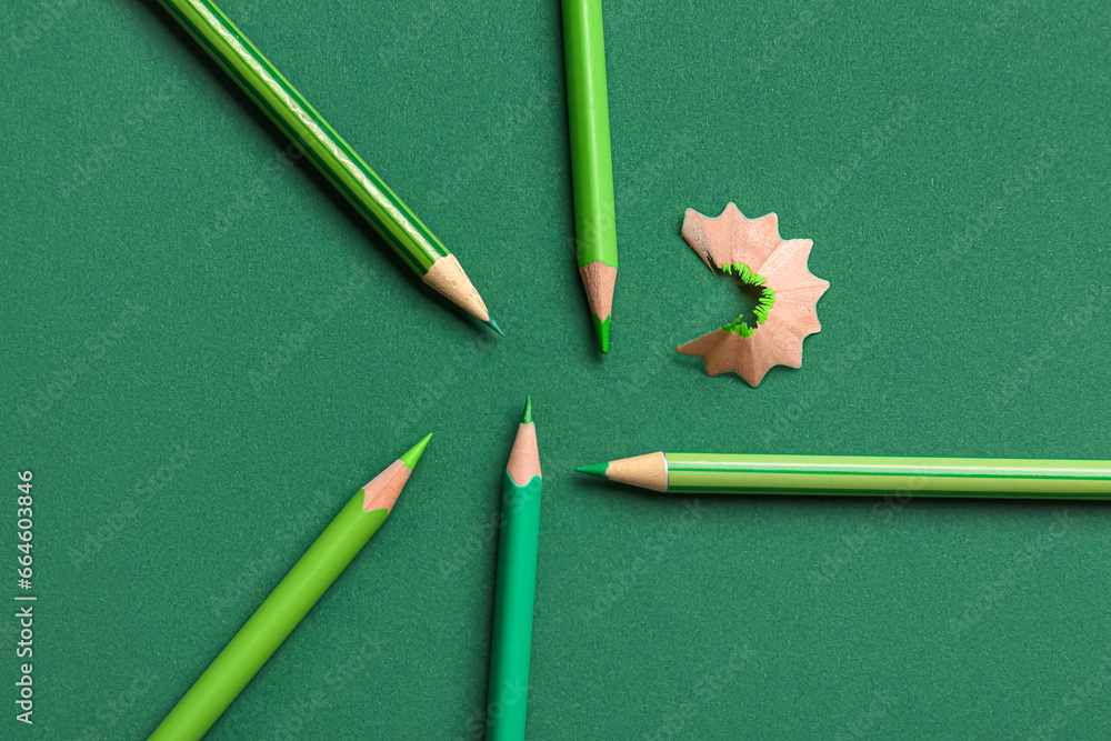 Set of color pencils on green background