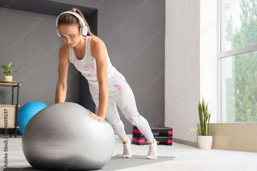 Young woman training with fitball in gym