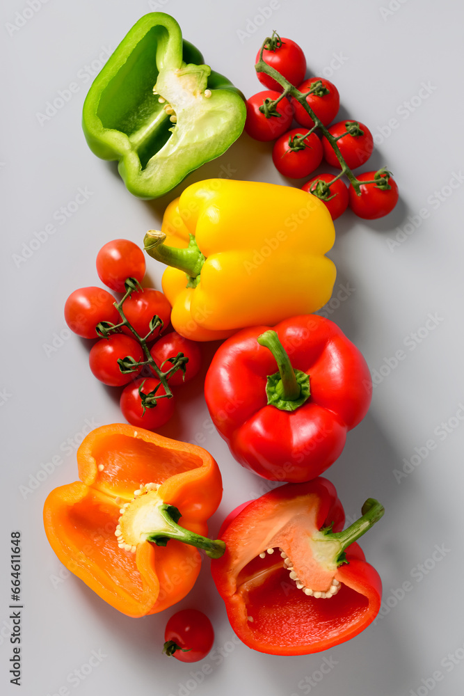 Fresh peppers and tomatoes on grey background