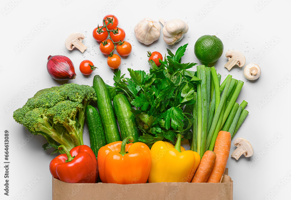 Paper bag with fresh vegetables, fruits and mushrooms on white background