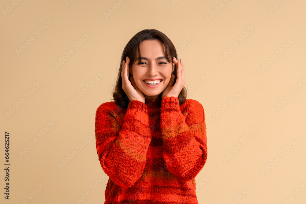 Young woman in red sweater on beige background