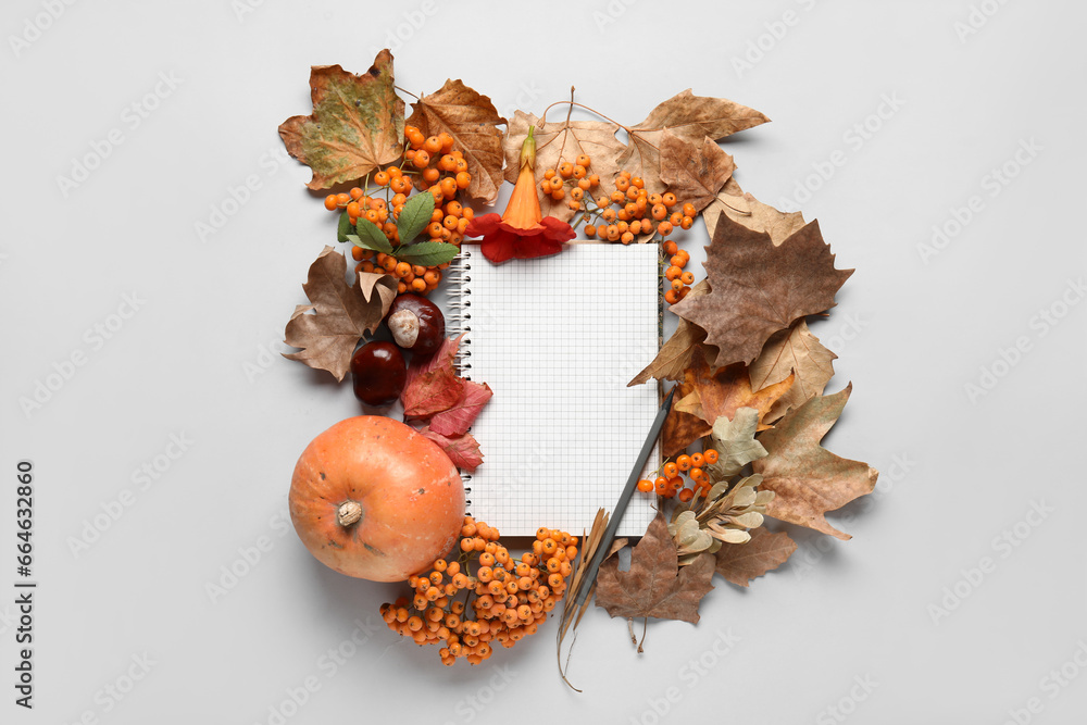 Blank notebook with autumn leaves, rowan, and chestnuts on white background