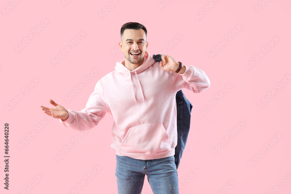 Happy young man on pink background