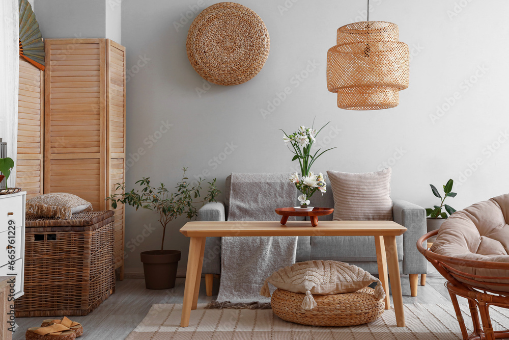 Interior of living room with sofa and ikebana on table