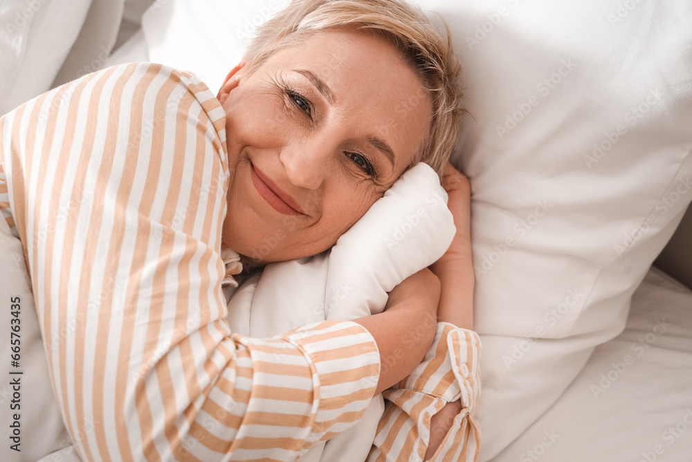 Mature woman lying in bed, closeup