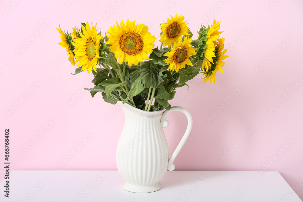 Vase with sunflowers on shelf near pink wall