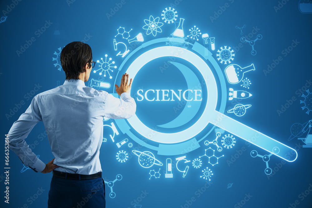 Back view of young businessman using creative glowing magnifier hologram on blue background. Science, research and medicine concept.