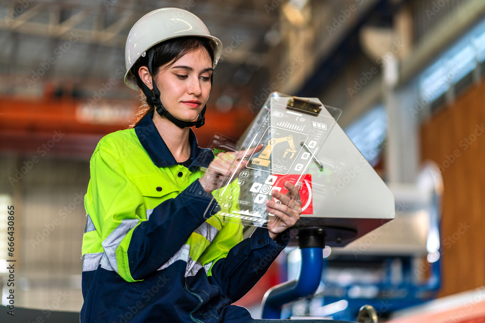 Professional machanic engineer technician industrial woman wearing safety uniform working control with tablet on heavy machine in manufacturing factory production line.business technology robot