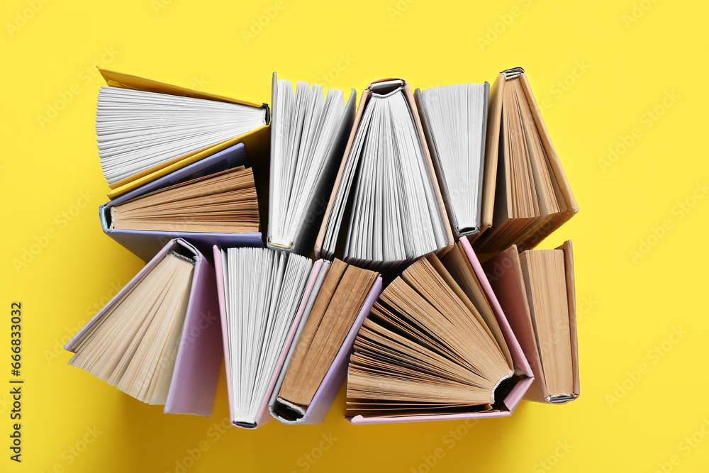 Many half open books on yellow background