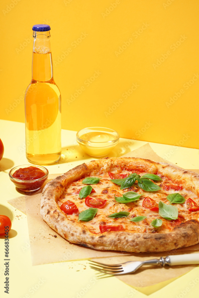 Baking paper with tasty pizza Margarita and basil on yellow background