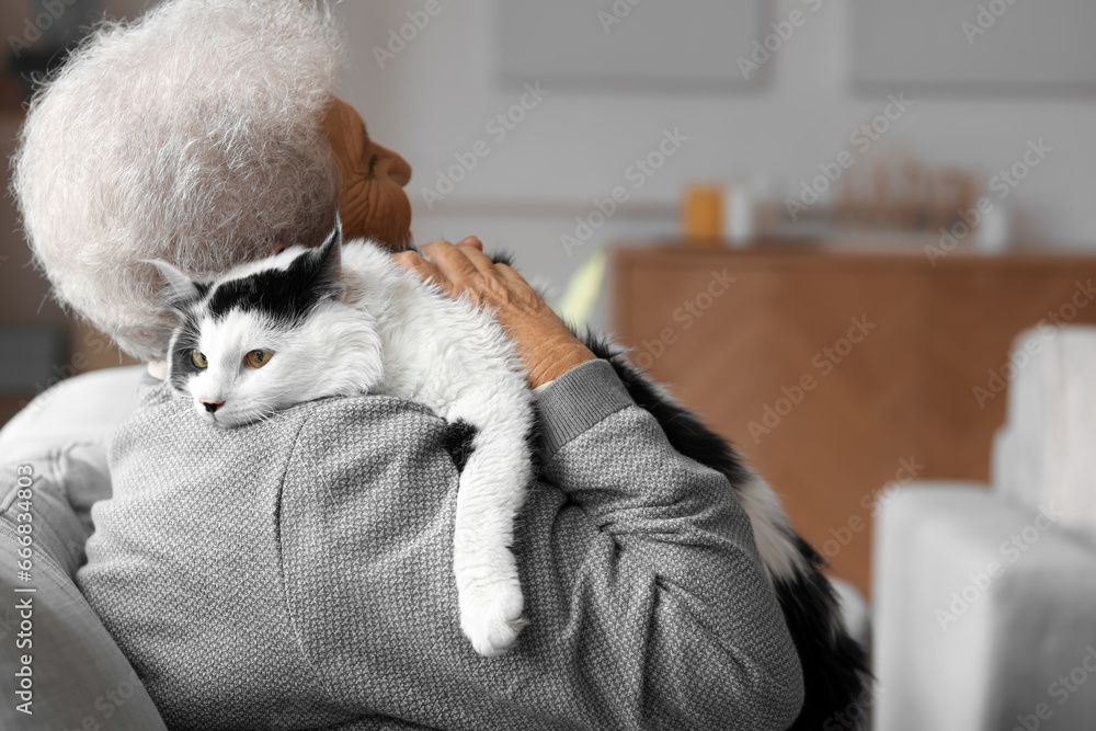 Senior woman with cute cat resting at home