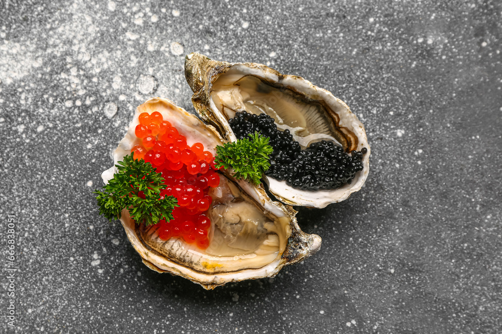 Tasty oysters with red and black caviar on grey background