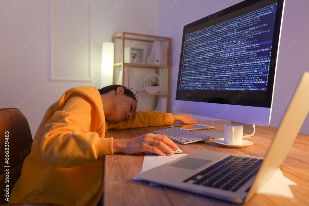 Tired young female programmer sleeping in office at night