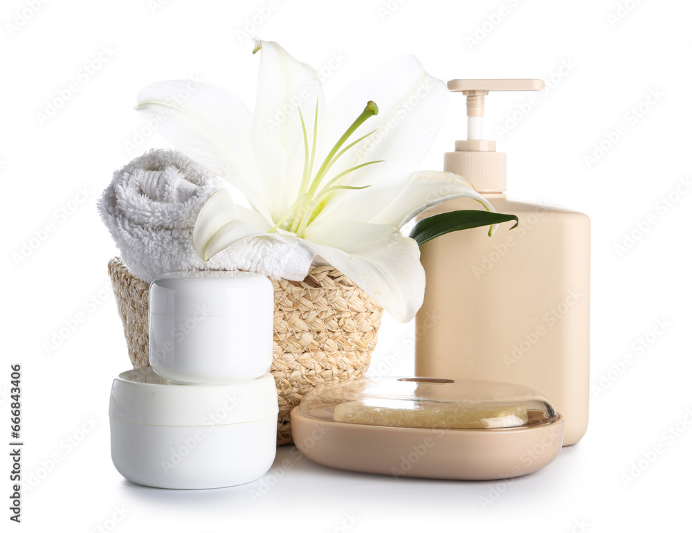 Set of cosmetic products, clean towel and lily flower on white background