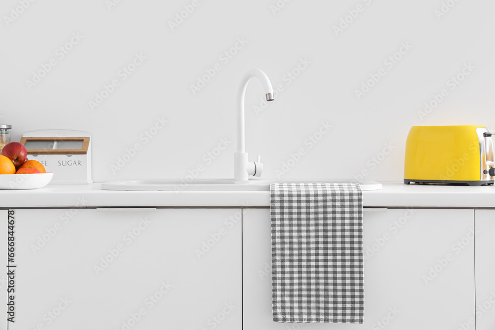 White kitchen counters with sink and yellow toaster