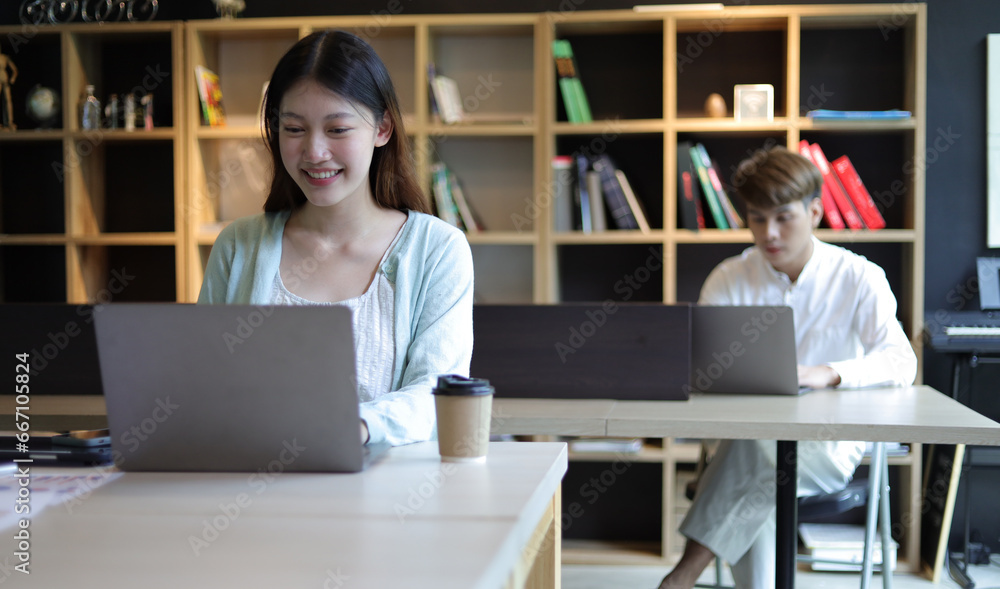 Asian female student working in university library.