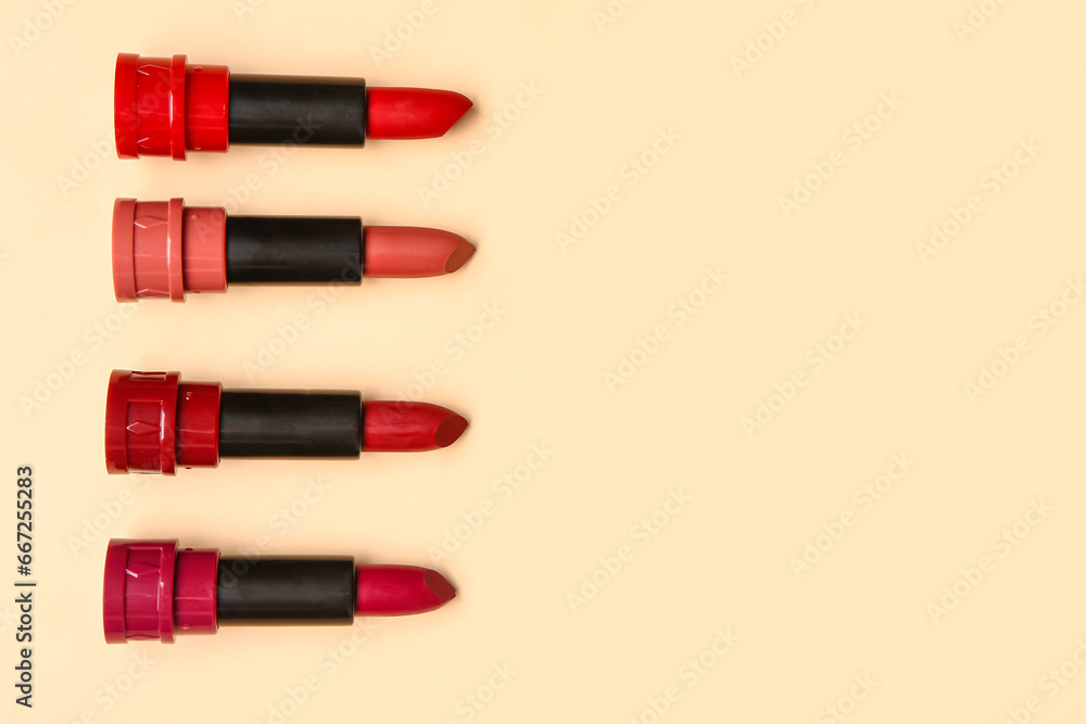 Different new lipsticks on beige background