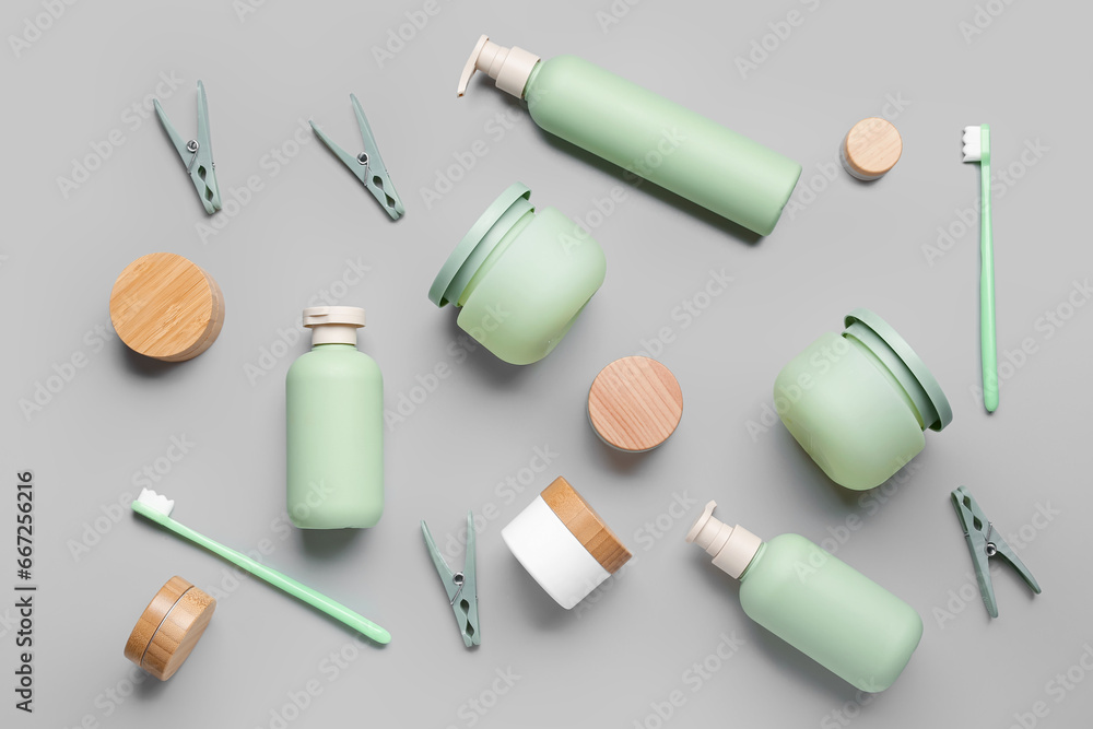 Composition with different cosmetic products, toothbrushes and clothespins on grey background