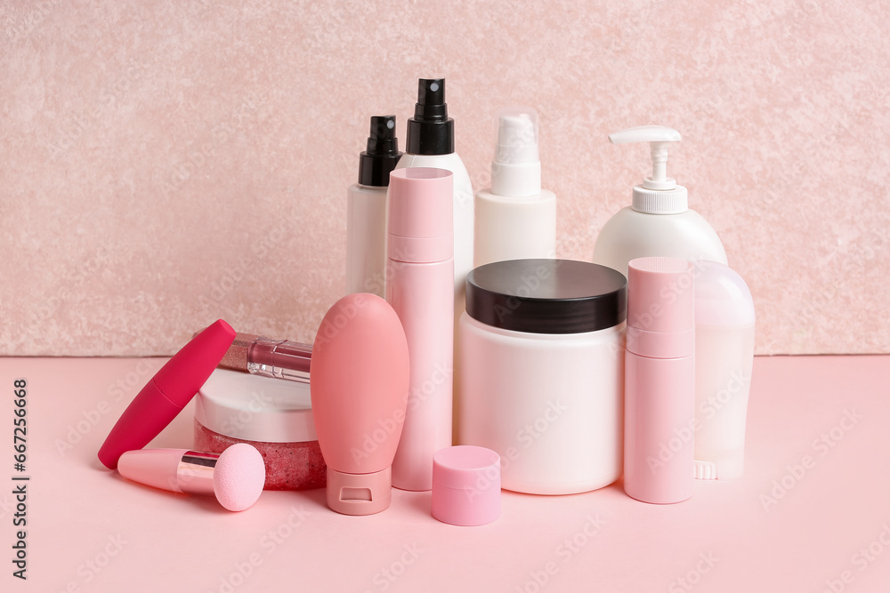 Set of different cosmetic products on pink background